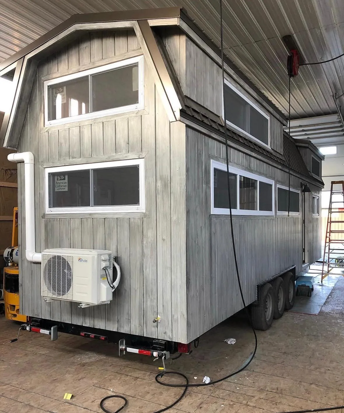Tiny home under construction inside the workshop, exterior cladding partly complete